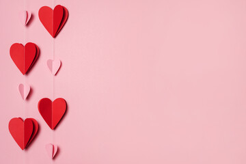 Paper garland from red and pink hearts On pink Background, copy space. Happy San Valentine Day....