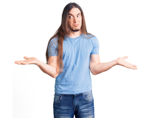 Young adult man with long hair wearing casual clothes clueless and confused expression with arms and hands raised. doubt concept.