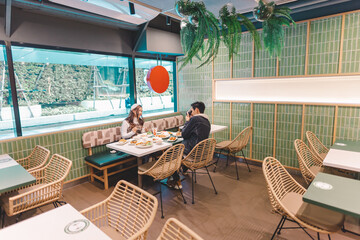 Couple taking photos together and eating at a Japanese restaurant