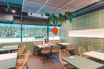 A woman eating food in a Japanese restaurant