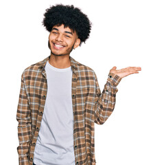 Young african american man with afro hair wearing casual clothes smiling cheerful presenting and...