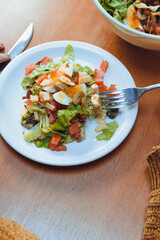 vertical image of unrecognizable woman eating salad in restaurant
