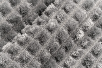 Gray rolled microfiber blanket. Plaid fluffy. Texture of a fluffy grey microfiber plaid. Warm fabric background.