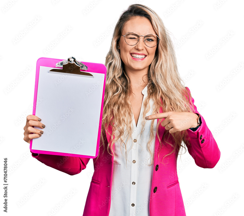 Sticker Young blonde woman holding clipboard winking looking at the camera with sexy expression, cheerful and happy face.