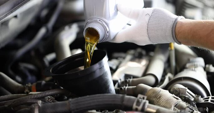 Locksmith pours car engine oil. Oil change in car concept