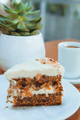 vertical image of slice of carrot cake served on white plate on table in cafe