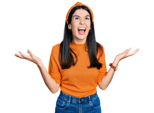Young hispanic woman wearing casual clothes crazy and mad shouting and yelling with aggressive expression and arms raised. frustration concept.