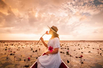 Zelfklevend Fotobehang Woman smelling flowers, view of vast lotus field © Kanbokeh