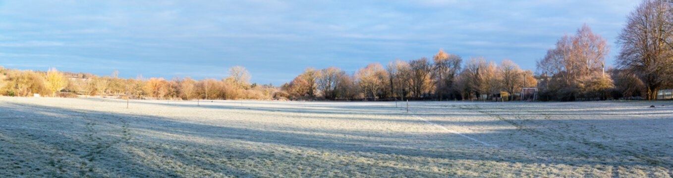 Frosty winter morning picture of a deserted playing field. Taken in wide angle panoramic format.