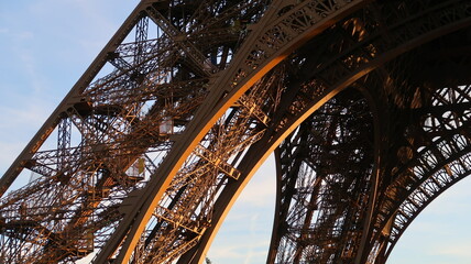 Détail d’architecture de la tour Eiffel, célèbre monument de la ville de Paris, zoom sur la structure d’une arche et de deux piliers sous le premier étage (France)