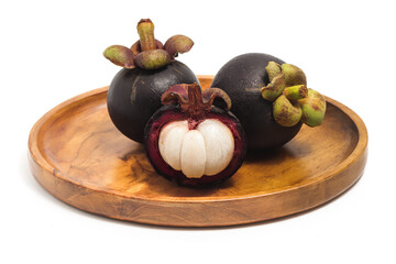 Half cut sliced and two whole fresh organic mangosteen delicious fruit in a wooden plate isolated on white background clipping path