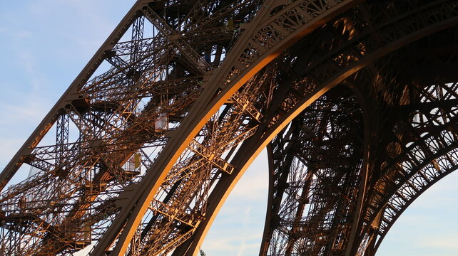 Fototapeta Détail d’architecture de la tour Eiffel, célèbre monument de la ville de Paris, zoom sur la structure d’une arche et de deux piliers sous le premier étage (France)