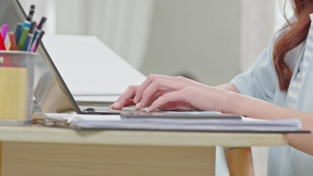 Close up hand of business woman typing on keyboard working with computer laptop. Hands of woman chatting or writing article on work table at home. B roll typing to communication on computer