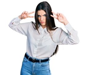 Young brunette teenager doing peace gesture close to eyes skeptic and nervous, frowning upset because of problem. negative person.