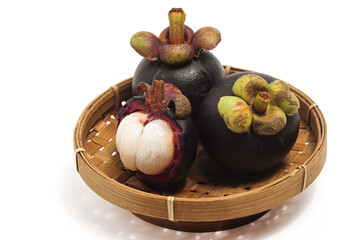 Half cut sliced and two whole fresh organic mangosteen delicious fruit in a bamboo basket plate isolated on white background clipping path