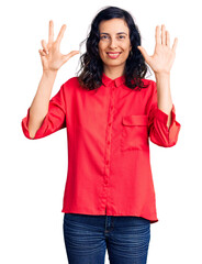 Young beautiful hispanic woman wearing casual clothes showing and pointing up with fingers number eight while smiling confident and happy.