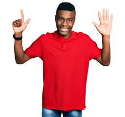 Young african american man wearing casual red t shirt showing and pointing up with fingers number seven while smiling confident and happy.