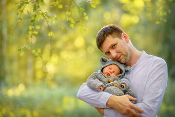 Beautiful, happy family on a walk in the park. Spring. Youngest son and dad. Dad gently holds the...