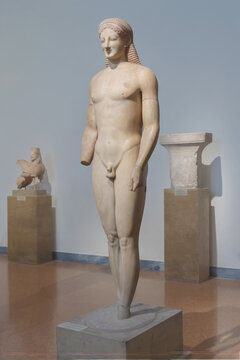 Archaic marble statue of naked young man, kouros, in Athenian museum. Dec 11, 2018. Athens, Greece