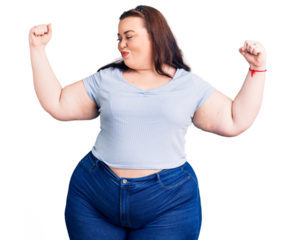Young plus size woman wearing casual clothes showing arms muscles smiling proud. fitness concept.