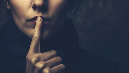 Foto op Canvas The Silence of Secrecy: A Mysterious Woman Gesturing for Silence with a Finger to Her Lips © Alienmonster Images