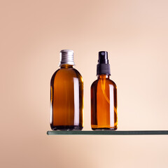 Glass brown bottle with cosmetic oil and spray serum, essential or serum stand on beige pastel background. Herbal homeopathic products. Natural organic spa cosmetics..