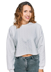 Beautiful young caucasian woman wearing casual winter sweater looking away to side with smile on face, natural expression. laughing confident.