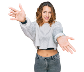 Beautiful young caucasian woman wearing casual winter sweater looking at the camera smiling with open arms for hug. cheerful expression embracing happiness.