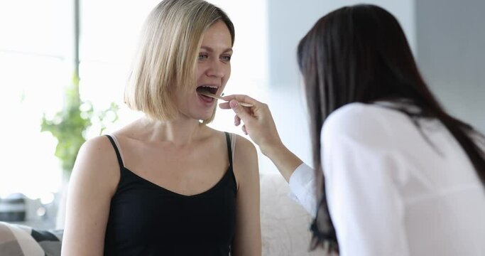Doctor medical examination of woman throat at home. Throat infection concept