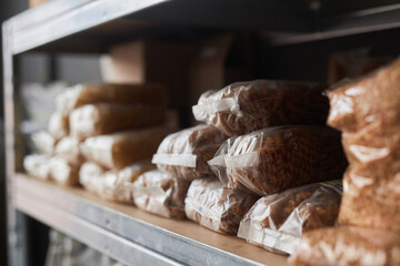 Background image of packaged food stacked on shelves in warehouse of refugee help center, copy space