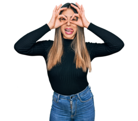 Young hispanic woman wearing casual clothes doing ok gesture like binoculars sticking tongue out, eyes looking through fingers. crazy expression.
