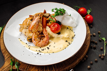 A dish of boiled shrimps with mashed potatoes, greens and vegetables