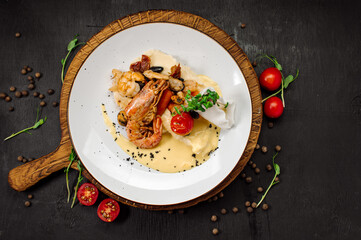 A dish of boiled shrimps with mashed potatoes, greens and vegetables