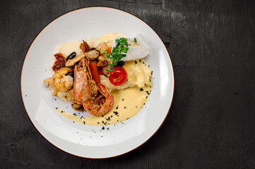 A dish of boiled shrimps with mashed potatoes, greens and vegetables