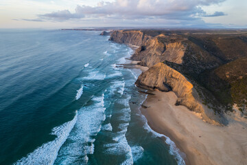 Obraz premium Cordoama beach in Portugal. Aerial drone view of waves, sandy beach and cliffs