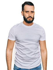 Fototapeta premium Young man with beard wearing casual white t shirt skeptic and nervous, frowning upset because of problem. negative person.