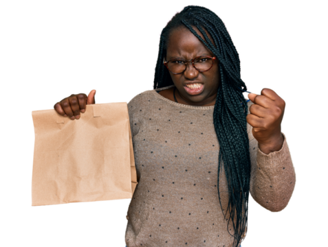 Young black woman with braids holding take away paper bag annoyed and frustrated shouting with anger, yelling crazy with anger and hand raised