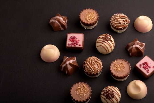 A tempting photo of a chocolate truffle assortment. This delicious candy and dessert selection, against a background, promises a tasty and sweet indulgence—making it an ideal gift 