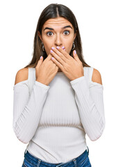 Young hispanic woman wearing casual clothes shocked covering mouth with hands for mistake. secret concept.