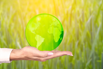 Environment day, save a clean planet, ecology concept. Earth Day. The hand holds the globe. A green business based on renewable energy can limit climate change and global warming. Poster.