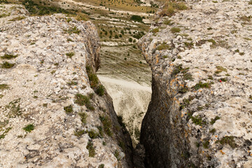 Huge gray rocks with a crevice and a view of the canyon. View from above. selective focus