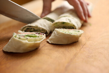 Wrapped in a roll pita bread is cut. Preparation of a roll with cheese, fish and vegetables