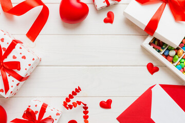 top view photo of st valentine day decor shopping, bag, envelope, gift, box, candy and red heart on colored background with empty space. Frame background