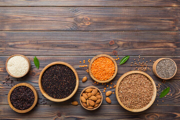 Various superfoods in smal bowl on colored background. Superfood as rice, chia, quinoa, lentils, nuts, sesame seeds, almonds. top view copy space