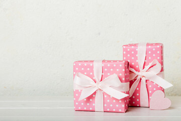 gift box with red bow and red heart on colored background. Perspective view. Flat lay