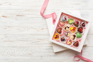 Holiday composition: sweet candy, with gift boxes with bow and chocolate hearts, photo template, background. Top View with copy space on colored background
