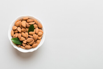 Fresh healthy Almond in bowl on colored table background. Top view