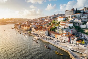 Panoramic view of the city of Oporto during sunset. Porto skyline. Magnificent sunset over downtown Porto and the Douro river, Portugal. The Dom Luis I bridge is a popular tourist spot. - obrazy, fototapety, plakaty