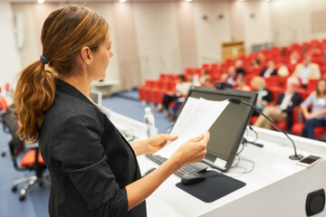 Speaker with document at business conference in auditorium