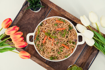 Tasty Vegetable hakka noodles in white plate and isolated background. Indo-Chinese vegetarian cuisine dish. Indian veg noodles with vegetables. Classic Asian meal - obrazy, fototapety, plakaty
